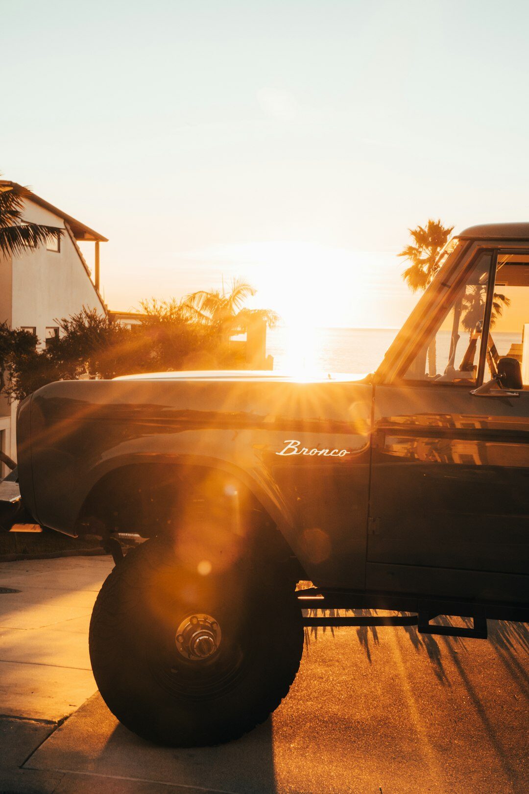 Vintage sports car driving along a coastal road at sunset in Punta del Este
